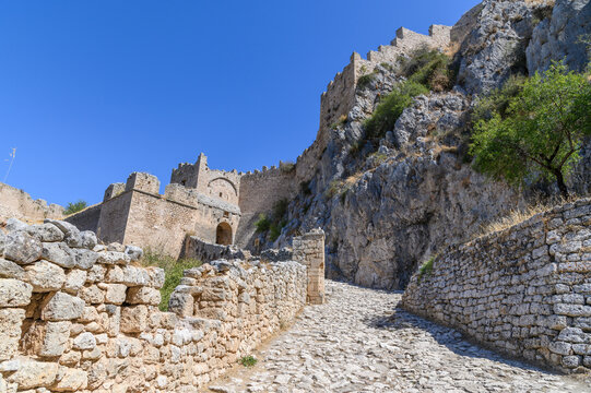 Crenellated gate towers and curtain wall of Acrocorinth seen from the cobbled ramp, Corinthia, Greece