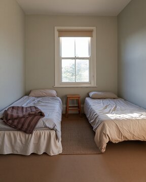 Compact twin bedroom with two single beds and crumpled linens in a restful, lived-in space for rental listings and small home living