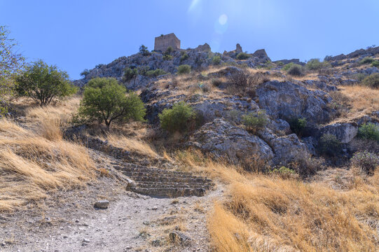 Ancient stone steps climbing the dry hillside towards the keep of Acrocorinth, Corinthia, Greece