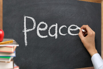Hand writing peace on a blackboard © nayefhammouri