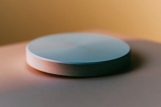 Blank round cardboard coaster with a smooth blue surface, featuring a fine paper texture and soft ambient lighting for a product mockup and design template