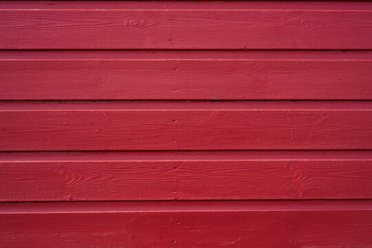 Red painted wood texture background with horizontal timber boards and visible grain