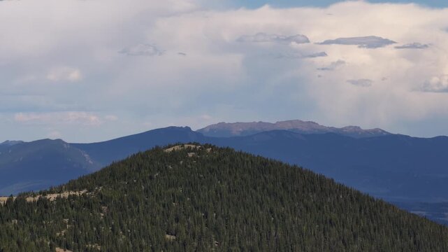 Aerial of forested hills and mountain ranges in Colorado near Keystone in summer