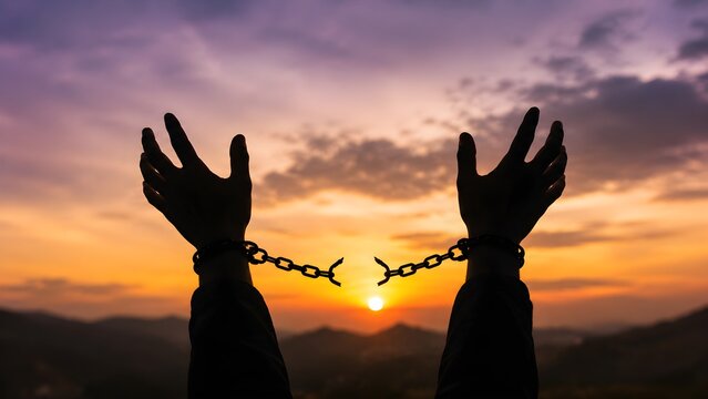 Raised hands breaking free from chains against a sunset symbolizing liberation freedom resilience hope justice empowerment and overcoming oppression