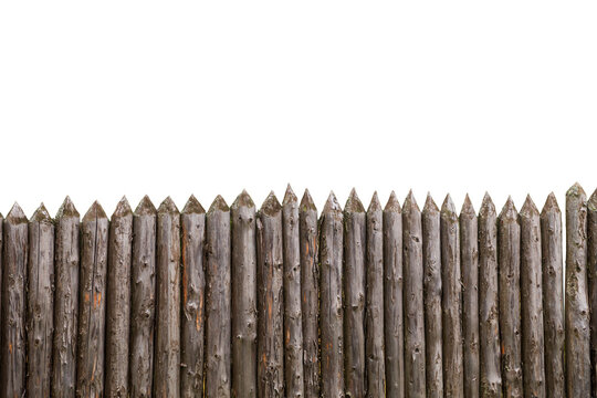 Weathered wooden palisade fence with sharpened pointed log stakes isolated on white background, cutout stock asset.