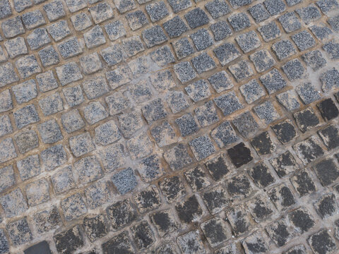 Top view of square cobblestone pavement with tactile tiles