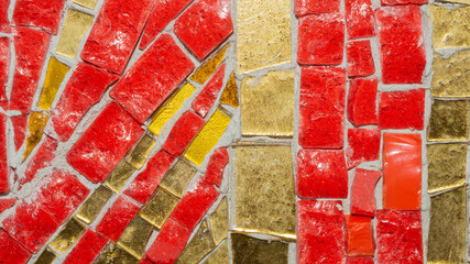 Macro of red and gold mosaic tiles with cement joints © maxkolmeto
