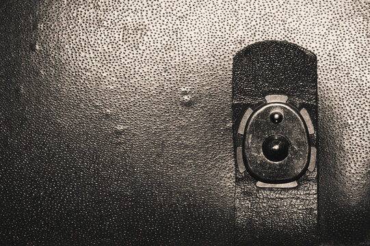 Vintage metal snap button clasp on dark grainy leather suitcase