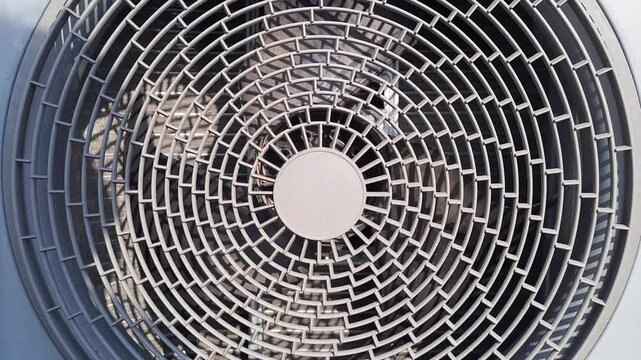 Close-up of a circular metal grille pattern on an air conditioner outdoor unit. Industrial technology and mechanical texture stock video footage.