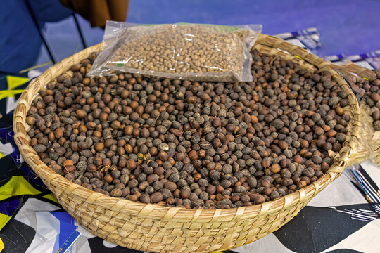 Pile of roasted coffee beans in rattan basket outside on market