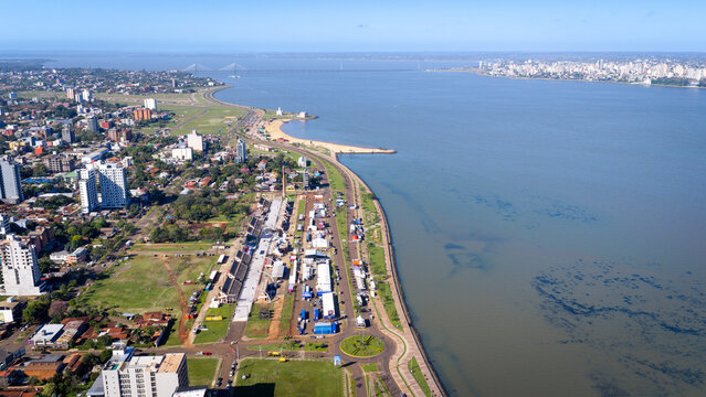 Aerial view of Encarnacion's riverside event setup with Posadas visible across the Parana River.