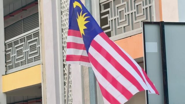  Malaysia Flag Waving on Building Facade During National Day Celebration