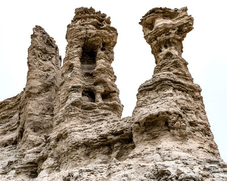Towering tufa formations rise majestically against a bright, overcast sky