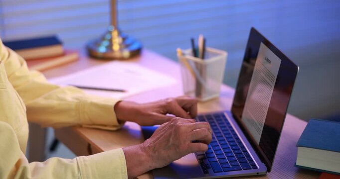 Author writing her book on laptop in office, closeup