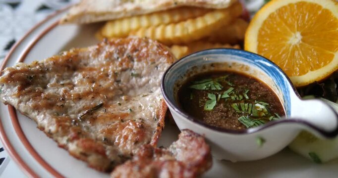 Flat lay top down shot of grilled black pepper pork chop steak set with french fries and garlic bread