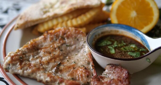Flat lay top down shot of grilled black pepper pork chop steak set with french fries and garlic bread