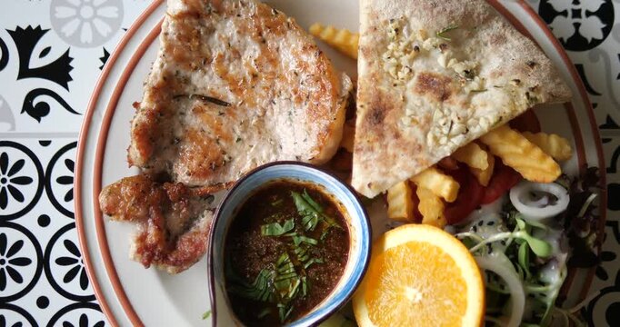 Flat lay top down shot of grilled black pepper pork chop steak set with french fries and garlic bread