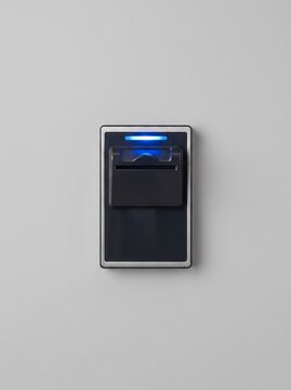 Fingerprint scanner with blue light on a gray wall  