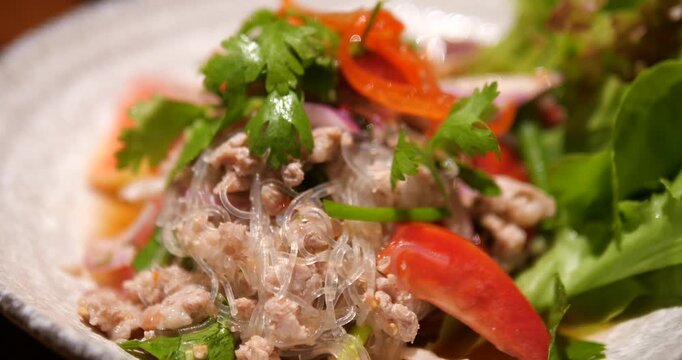 Close up of Thai spicy glass noodle salad with minced pork and vegetables