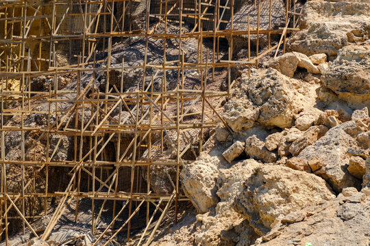 Wooden scaffolding structure installed against an eroding rock cliff for geotechnical slope stabilization