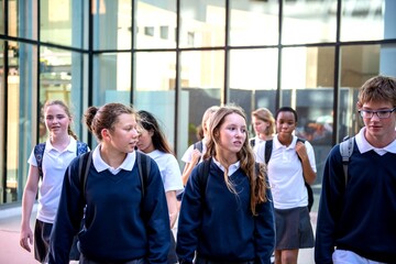 Obraz premium Students walking outside school building.