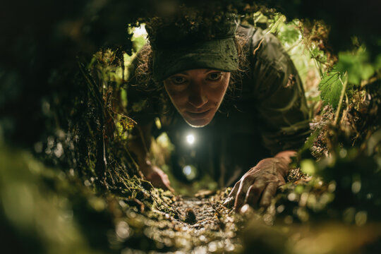 Ecologist examines a narrow wildlife passage surrounded by vegetation, illustrating habitat monitoring, biodiversity research, conservation and wildlife protection.