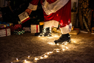 Obraz premium Santa placing gift under tree.