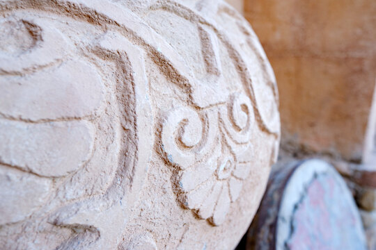 Close up of decorative carved stone vessel with floral pattern in historical setting