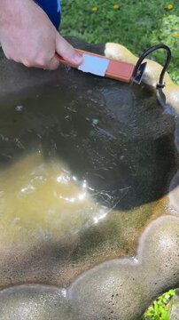 Man Cleaning Outdoor Birdbath With Heavy Duty Scrub Brush