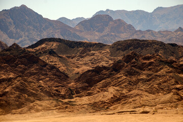 Naklejka premium Layered desert mountains under bright daylight showing vast dry landscape and peaks