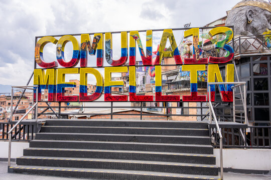 Comuna 13 medellin sign showcasing colombia's flag colors and vibrant street art, symbolizing urban transformation
