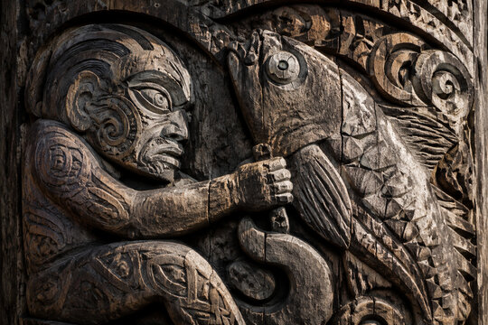 A Hawaiian fisherman's wooden totem carving depicting a struggle with a large fish, weathered texture.