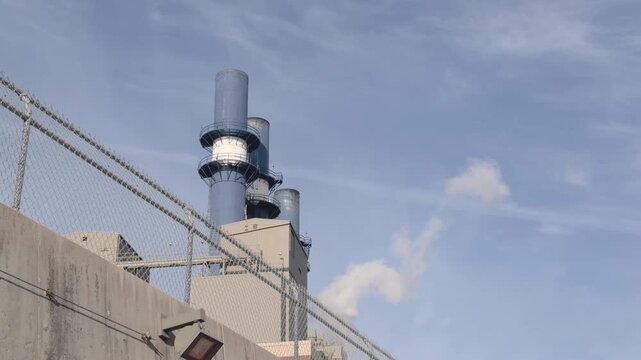 Industrial view behind fence of smoke stack from factory 4k
