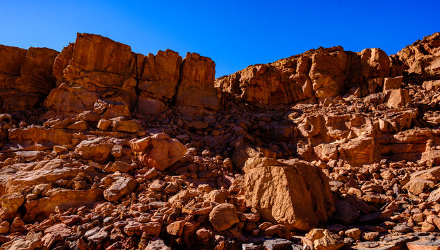 Rocky canyon terrain with rugged sandstone boulders and bright blue sky