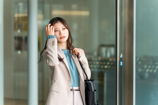 A young Asian businesswoman walking through a city office district.