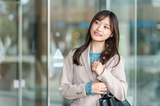 A young Asian businesswoman walking through a city office district.