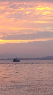 Fishing Boat on Calm Sea at Colorful Sunset