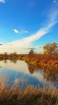 Vertical autumn lake timelapse with colorful trees and clouds