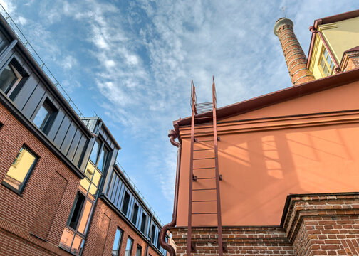 old factory building after reconstruction with the kept fragment of an old bricklaying and a brick pipe.