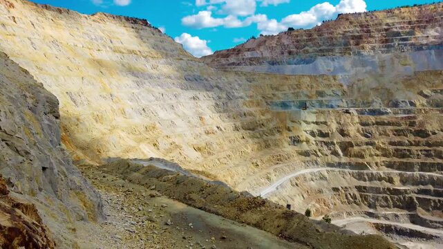 Aerial view of massive open pit copper mine at Rosia Poieni in Alba County, Romania. Massive Terraced Open Pit Mine in the Apuseni Mountains. Human Impact on Nature, Giant Stepped Terraces of Surface 