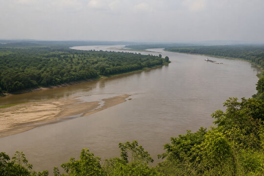 View from high bluff of wide brown river bending through low green forest, sandbar, tugboat and barge downstream, Mississippi River landscape