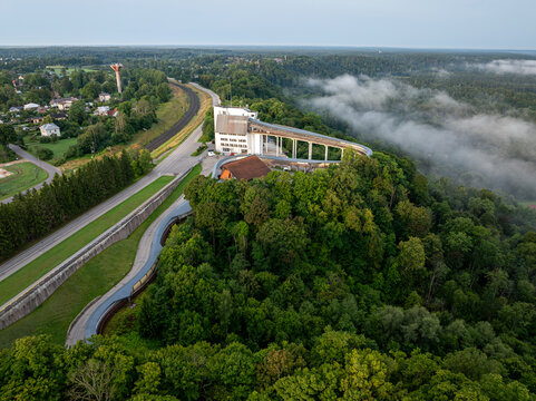 Aerial view of bobsleigh and luge track surrounded by forest and morning mist in Sigulda, Latvia