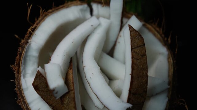 Fresh coconut slices and white flesh in a coconut shell, showing tropical food texture and natural ingredients