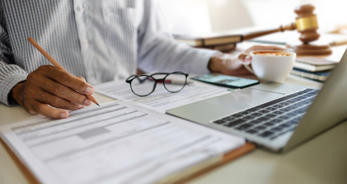 close up shot, asian businessman using laptop working on desk. legal expert, professional lawyer reading and checking financial document and business contract