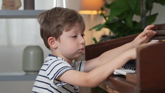 Little boy learning to play the vintage organ at home, Young child practicing music on antique electronic organ, Kid playing the keys of a vintage musical instrument in cozy room