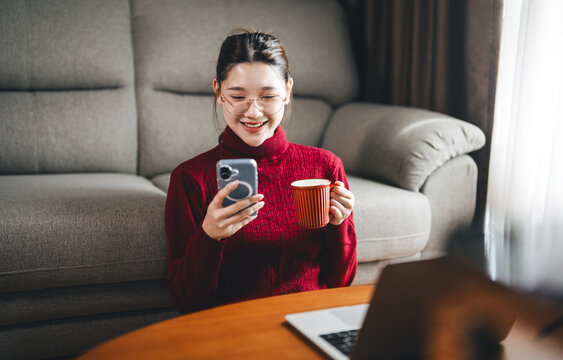 Young adult asian woman freelance working from home using laptop gen z stay alone lifestyles in apartment