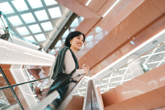 Elegant business woman standing on escalator enjoy at department store financial freedom lifestyle