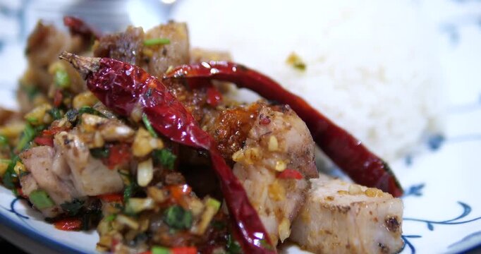 Close up of stir fried crispy pork belly with chili and garlic on rice