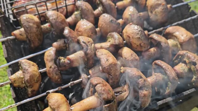 Grilling mushrooms on skewers and kebabs at a backyard barbecue in summer