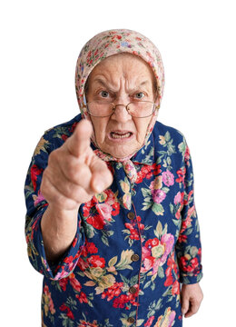 Elderly woman scolds and points directly at the camera while wearing a floral headscarf and dress. Facial expression is stern and confrontational, suitable for warning or admonition themes.